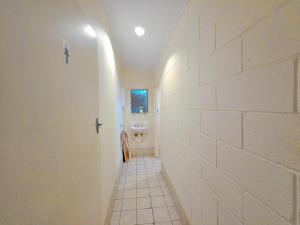 a bathroom with a sink and a white wall at Eden - Franklin 6 in Adelaide