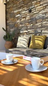 two coffee cups on a wooden table with a couch at Egeo Paros in Kampos Paros +71 photos