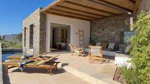 a patio with chairs and a couch on a house at Egeo Paros in Kampos Paros