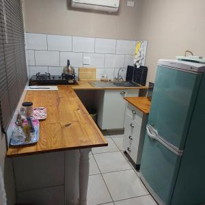 a kitchen with a wooden table and a refrigerator at 1atKruger Unit 2 in Mokopane