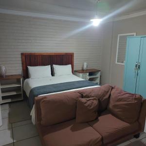 a bedroom with a bed and a couch in front of it at 1atKruger Unit 2 in Mokopane
