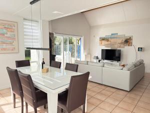 a dining room with a table and a couch at Ooghduyne 89 in Julianadorp