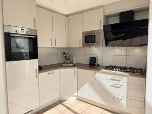 a white kitchen with white cabinets and appliances at Ooghduyne 89 in Julianadorp +15 photos