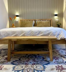 a bed in a room with a wooden bed frame at זוג ידיים - סוויטה עם בריכה פרטית, סאונה וג'קוזי in H̱osen +15 photos