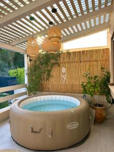 a hot tub on a patio with a pergola at זוג ידיים - סוויטה עם בריכה פרטית, סאונה וג'קוזי in H̱osen