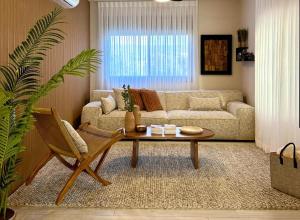 a living room with a couch and a coffee table at זוג ידיים - סוויטה עם בריכה פרטית, סאונה וג'קוזי in H̱osen