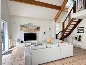 a living room with a white couch and a tv at Ooghduyne 89 in Julianadorp