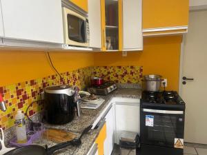 a kitchen with a stove and a counter top at GAVOA Beach FLAT in Água Boa