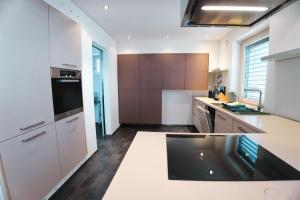 a kitchen with white counters and brown cabinets at EK-Living in Fügen