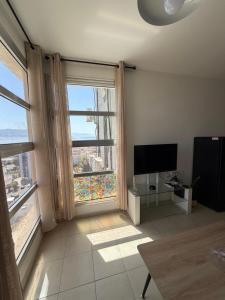 a living room with two large windows and a flat screen tv at Room 805 in Eilat