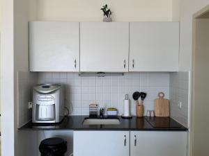 a kitchen with white cabinets and a counter top at Room 805 in Eilat +5 photos