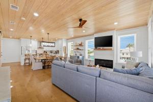 a living room with blue couches and a dining room at The Perch in Gulf Shores