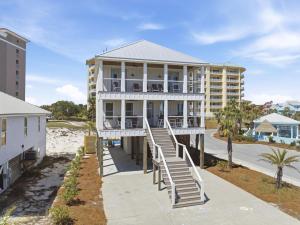 a white house with stairs leading to the beach at The Perch in Gulf Shores