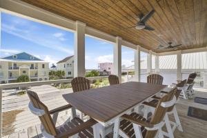 a dining room with a table and chairs on a deck at The Perch in Gulf Shores