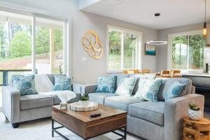 a living room with two couches and a coffee table at Cliffside Modern Villa. Secluded and accessible. in Asheville