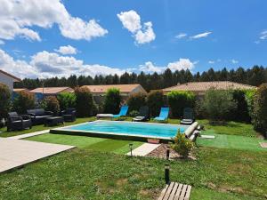 a swimming pool in a yard with chairs around it at TURQUOISE in Linxe