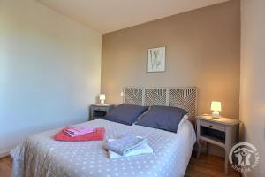 a bedroom with a bed with two tables and two lamps at Maison d'hôtes de kervor in Plouézec