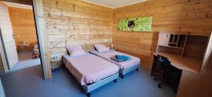 a bedroom with two beds and a desk in it at La Maison En Bois in Figeac