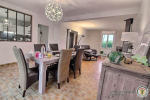 a dining room and living room with a table and chairs at Maison d'hôtes de kervor in Plouézec
