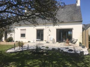 a white house with a patio in the yard at Maison d'hôtes de kervor in Plouézec