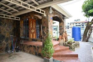 a stone house with a porch with a wooden door at Patong Beach private Villa in Patong Beach