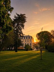 a building in a field with a tree in front of it at BABEL COMMUNITY Hôtel Bordeaux in Bordeaux