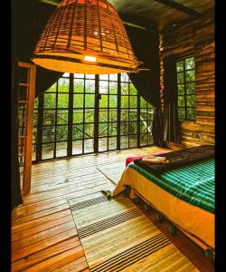 a bedroom with a bed and a large window at TheCabinsNanyuki in Nanyuki