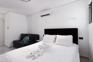 a bedroom with a white bed with a black headboard at Coral suites Boutique in Eilat +71 photos