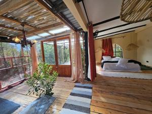 a bedroom with a bed in a room with windows at TheCabinsNanyuki in Nanyuki
