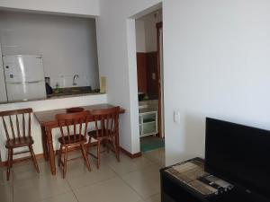a kitchen with a wooden table and chairs in a room at Privileg in Ilhéus