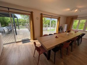 a dining room with a large wooden table and chairs at La maison Callinora in La Chapelle-Saint-Étienne