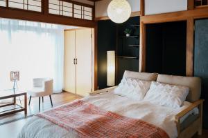 a bedroom with a bed and a table and a chair at Nagoya kiyosu温もりの宿貸切一軒家駅近3分 in Nishi-biwajima