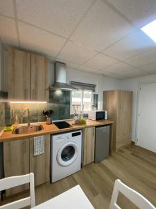 a kitchen with a washing machine and a sink at BEACH Arguineguin FIRST LINE CHG FAMILY HOTEL in Arguineguín