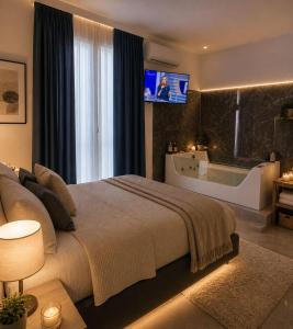 a bedroom with a bed and a tub and a tv at Duomo Luxury Suite Catania in Catania