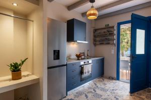 a kitchen with blue cabinets and a blue door at Apágkio Filoxenia in Archangelos