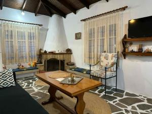 a living room with a table and a fireplace at Casa de Palma in Asprovalta