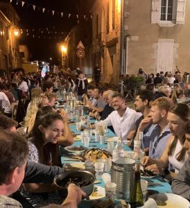 a group of people sitting at tables eating food at Pion La Grange - cottage barn conversion in Castelnau-dʼAuzan