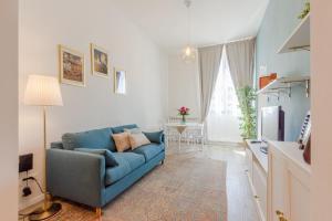 a living room with a blue couch and a television at Le Case di Sonia Maison Mami' in Fucecchio