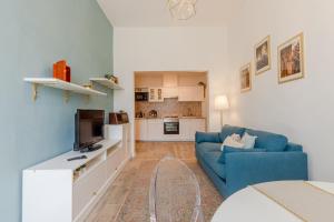 a living room with a blue couch and a tv at Le Case di Sonia Maison Mami' in Fucecchio +19 photos