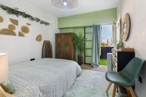a bedroom with a bed and a chair and a window at Beach fun in Costa da Caparica