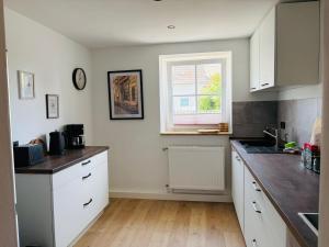 a kitchen with white cabinets and a window at Fewo Seestern in Neukieritzsch