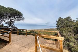 a wooden deck with a view of the ocean at Beach fun in Costa da Caparica