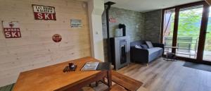 a living room with a couch and a tv in it at Chalet des Edelweiss, Guzet in Ustou