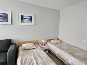 a bedroom with two beds and a couch at Side Korterid in Rakvere