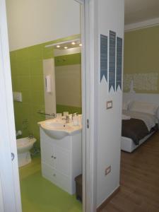 レッチェにあるSan Andreas Suitesのバスルーム(シンク、鏡、ベッド付)