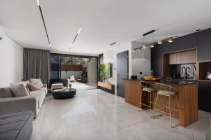 a kitchen and living room with a couch and a table at Coral suites Boutique in Eilat