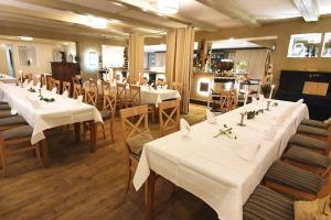 a restaurant with tables and chairs with white tablecloths at Hotel Restaurant Rodetal in Nörten-Hardenberg