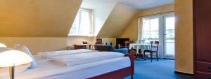 a bedroom with a bed and a table and chairs at Hotel Restaurant Rodetal in Nörten-Hardenberg