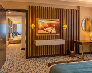 a hotel room with a bed and a desk at Royal Crown Muscat in Muscat +22 photos