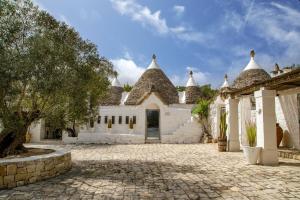 a large white building with a stone driveway at Puntebianche Resort in Ceglie Messapica